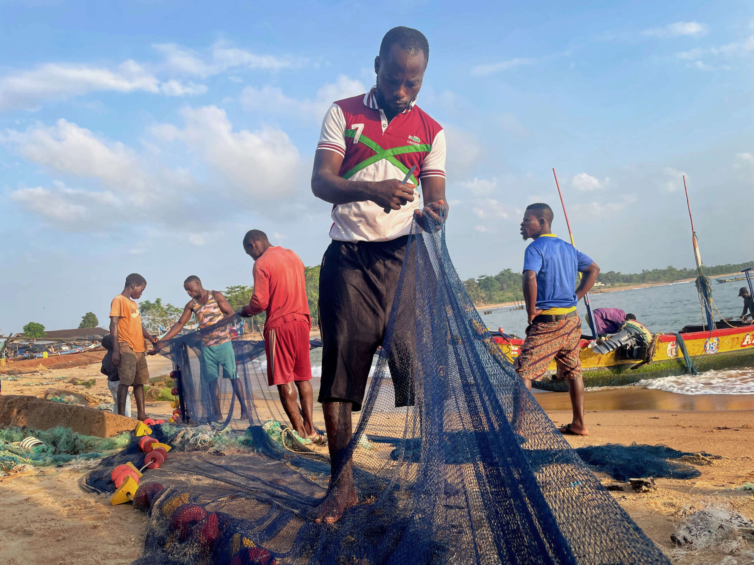 Pêcheurs réparent des filets sur la plage de Grand Béréby, Côte d'Ivoire - par Rich Press